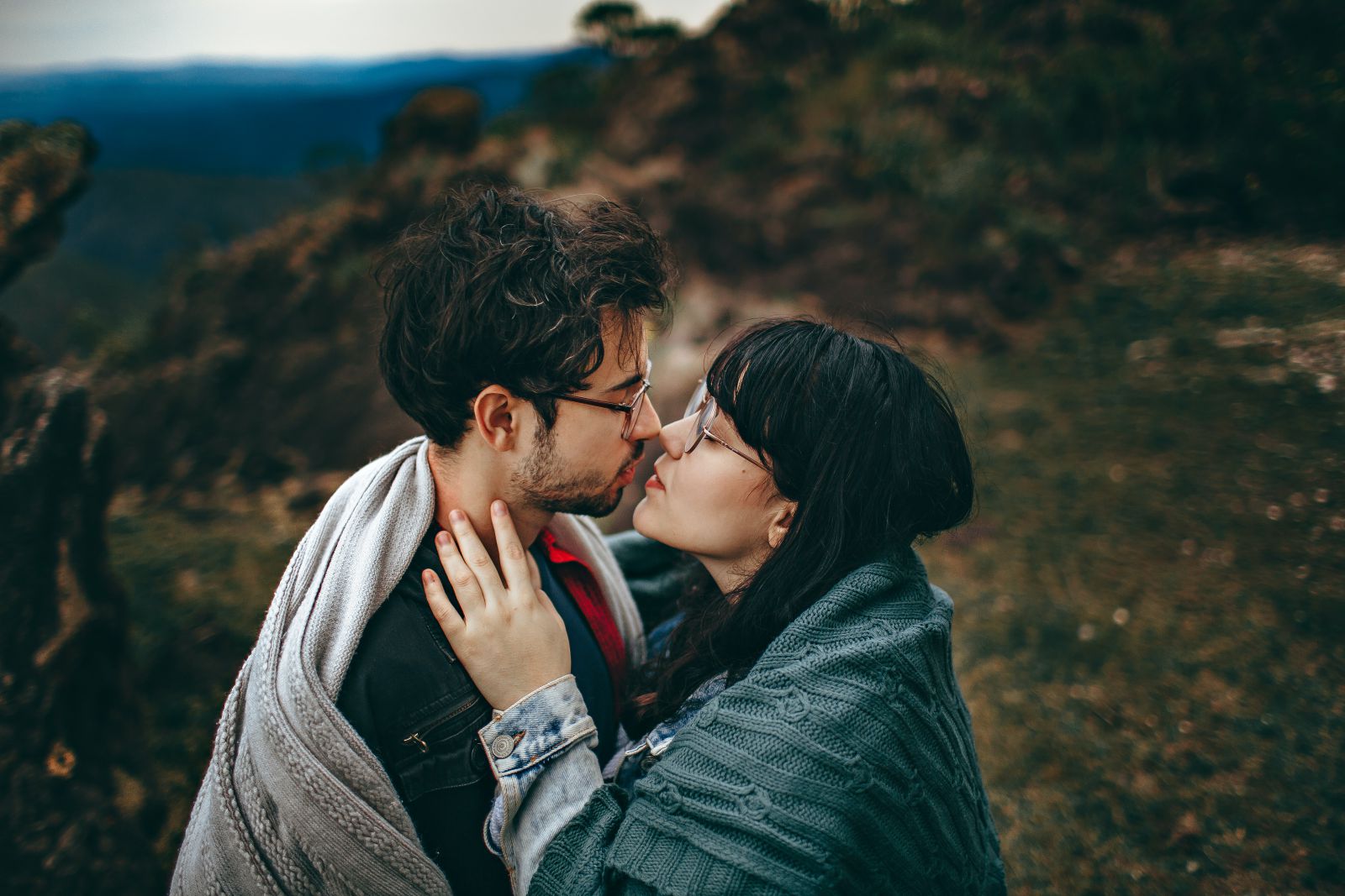 Casal de homem e mulher em uma montanha com seus rostos próximos