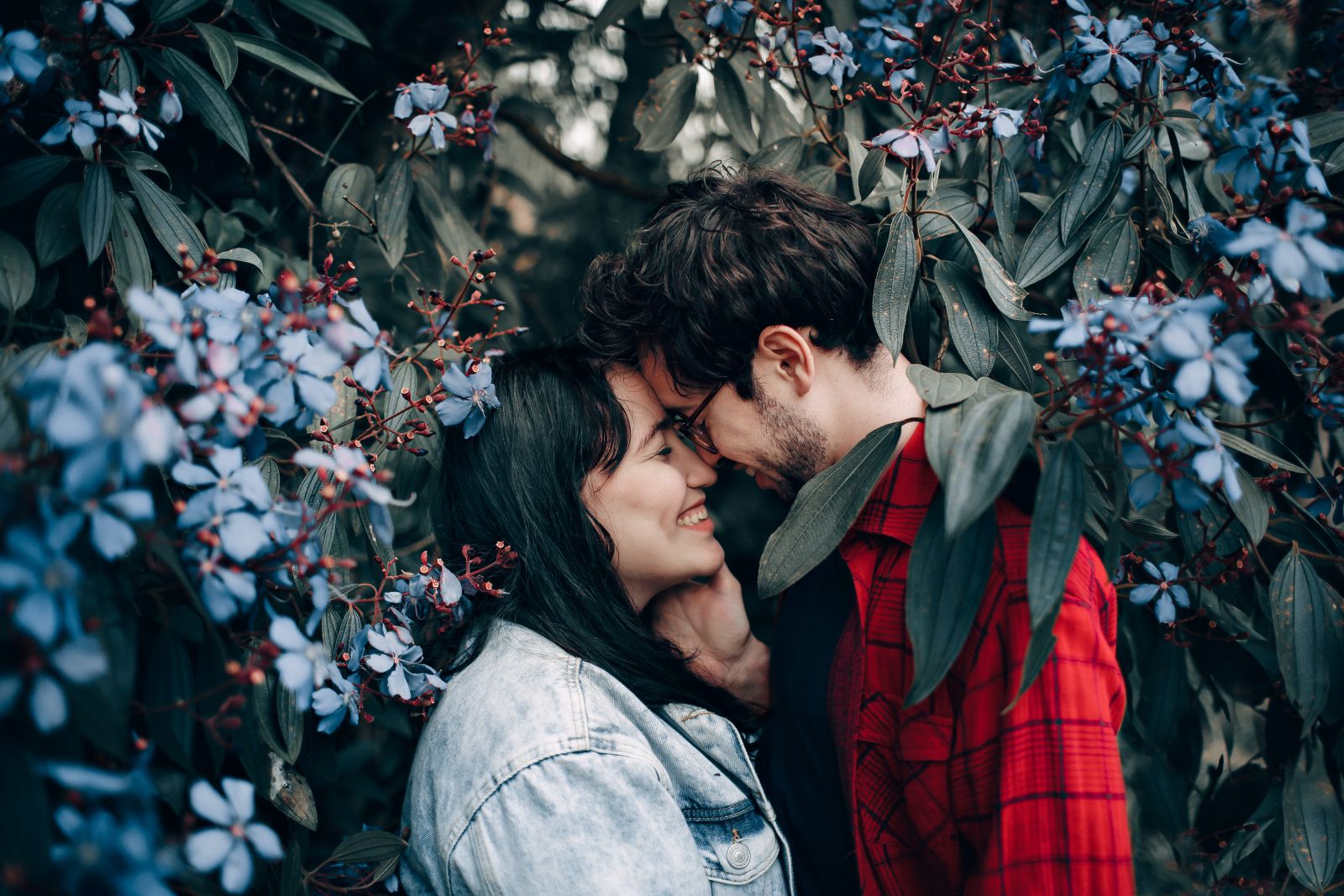 Homem e mulher de olhos fechados em meio a flores