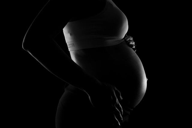 Imagem de uma mulher grávida vista de perfil