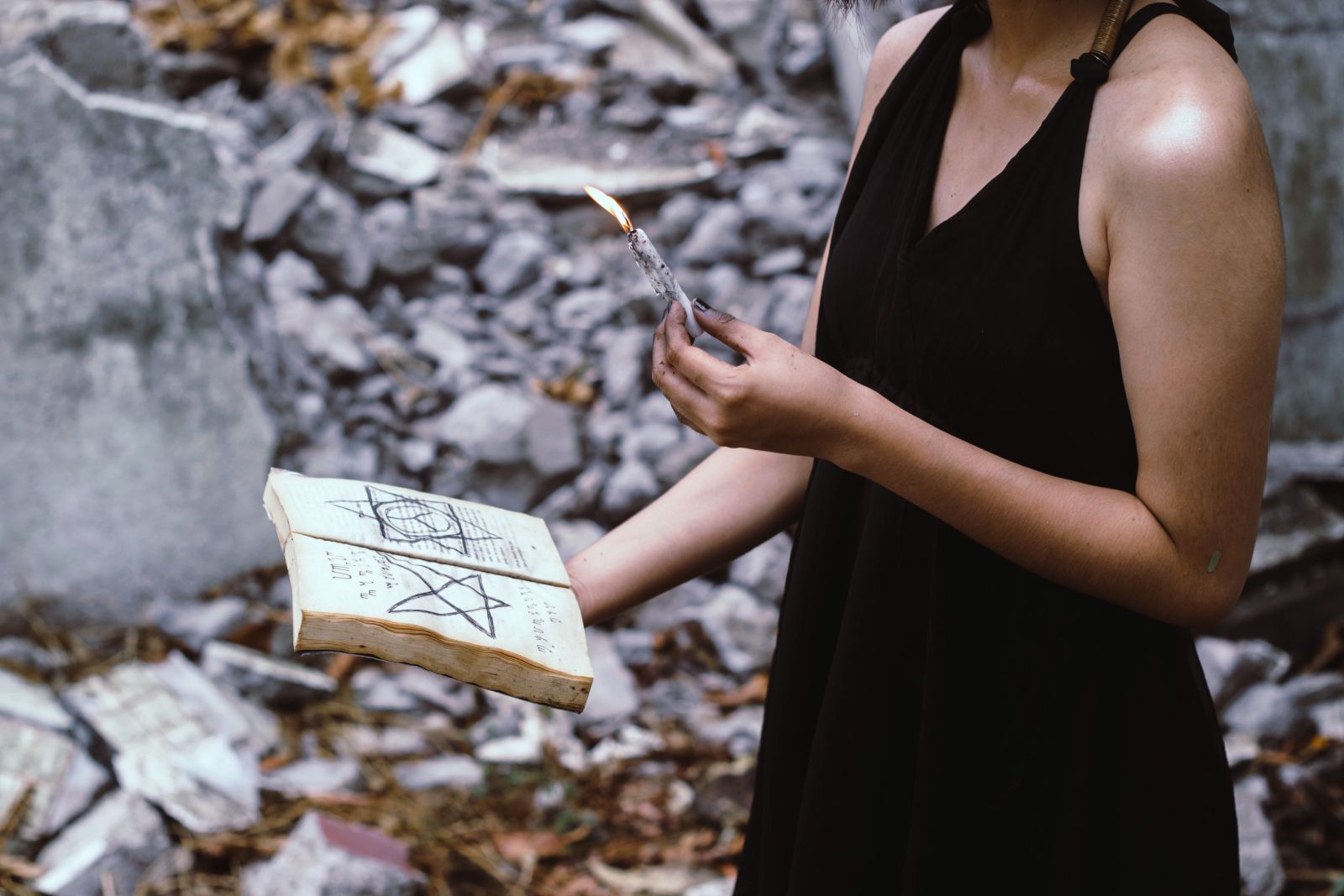 Mulher em uma floresta segurando livro e uma vela