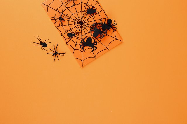 Aranhas fictícias numa folha laranja.
