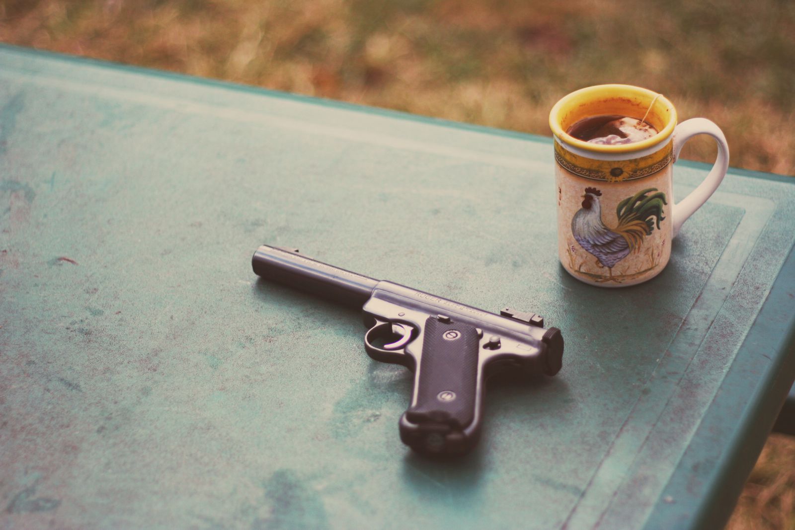 Arma ao lado de uma xícara de chá