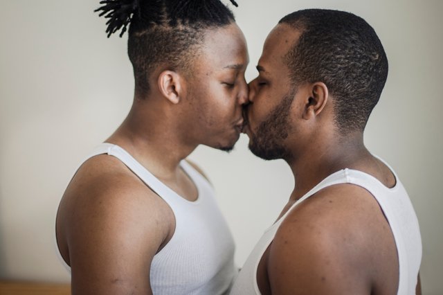 Casal homoafetivo se beijando visto de lado