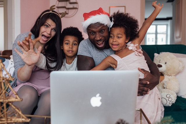 Família negra fazendo chamada de vídeo por um computador.