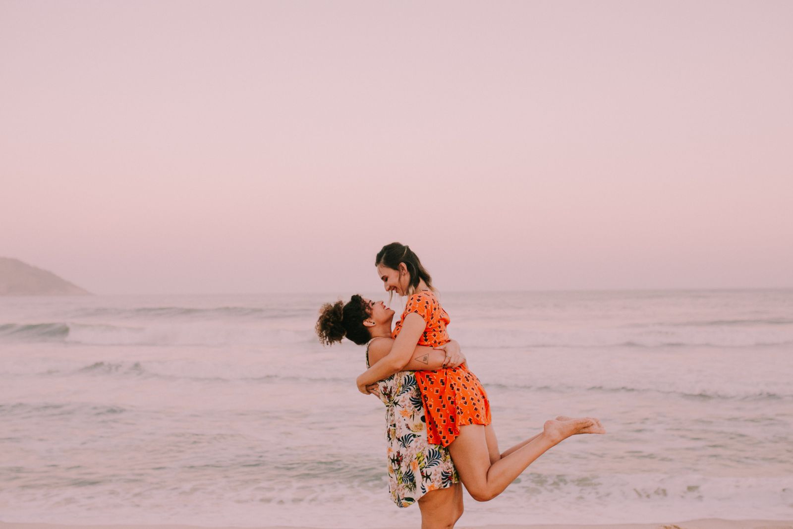 Casal de mulheres na praia se abraçando
