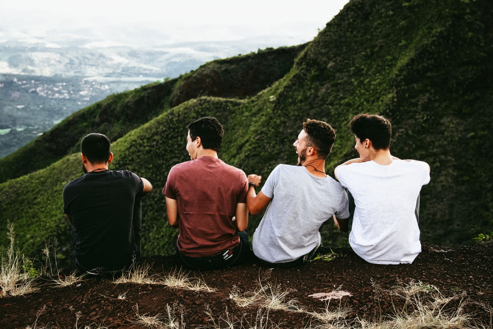 Grupo de homens sentados em uma montanha conversando