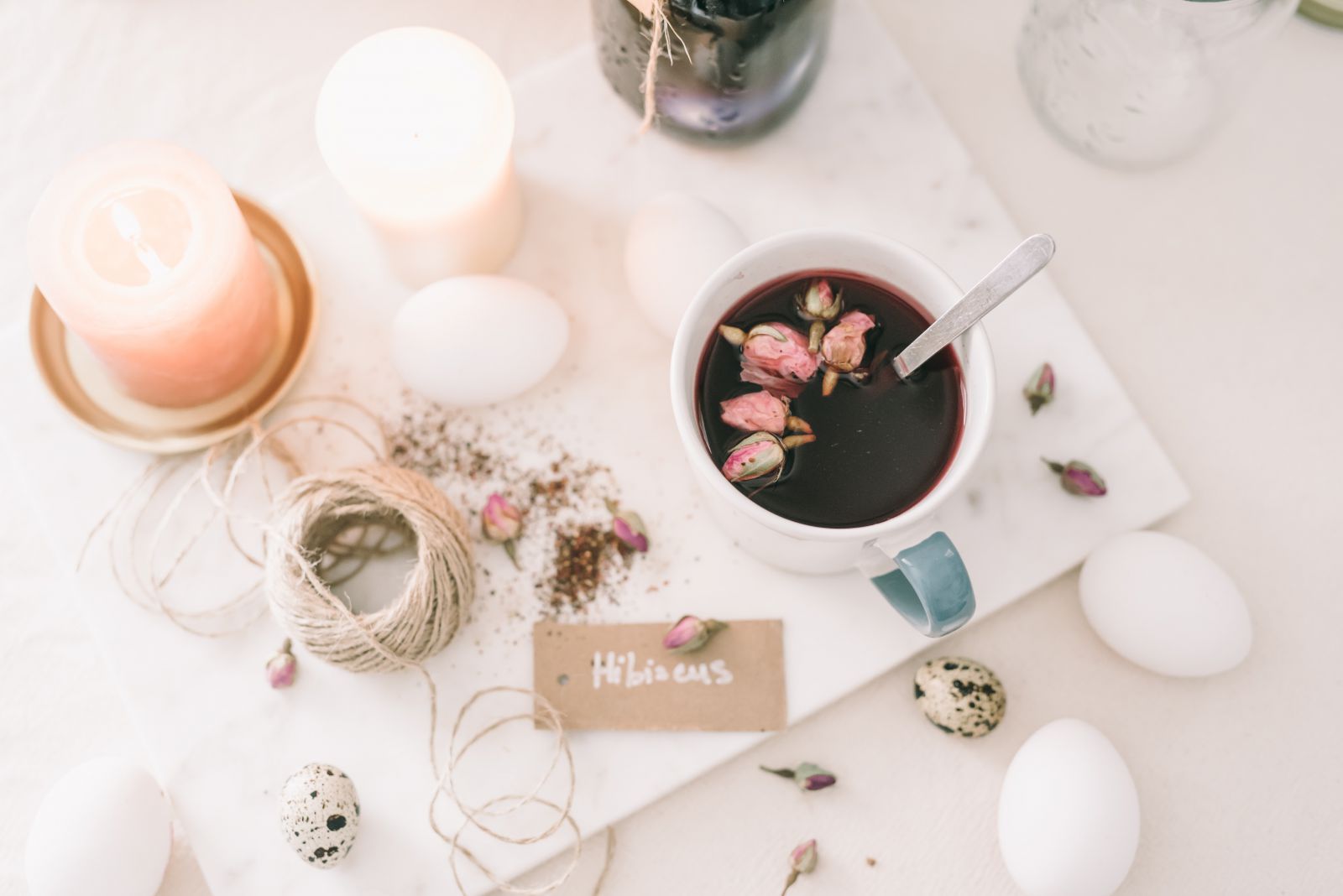 Mesa  com chá, velas e botões de flor