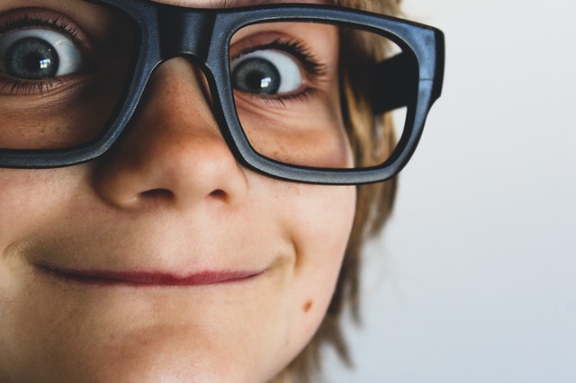 Criança usando óculos grande visto de perto