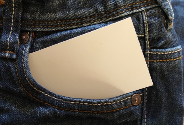 Carta branca dentro de envelope esquerdo de calça jeans.