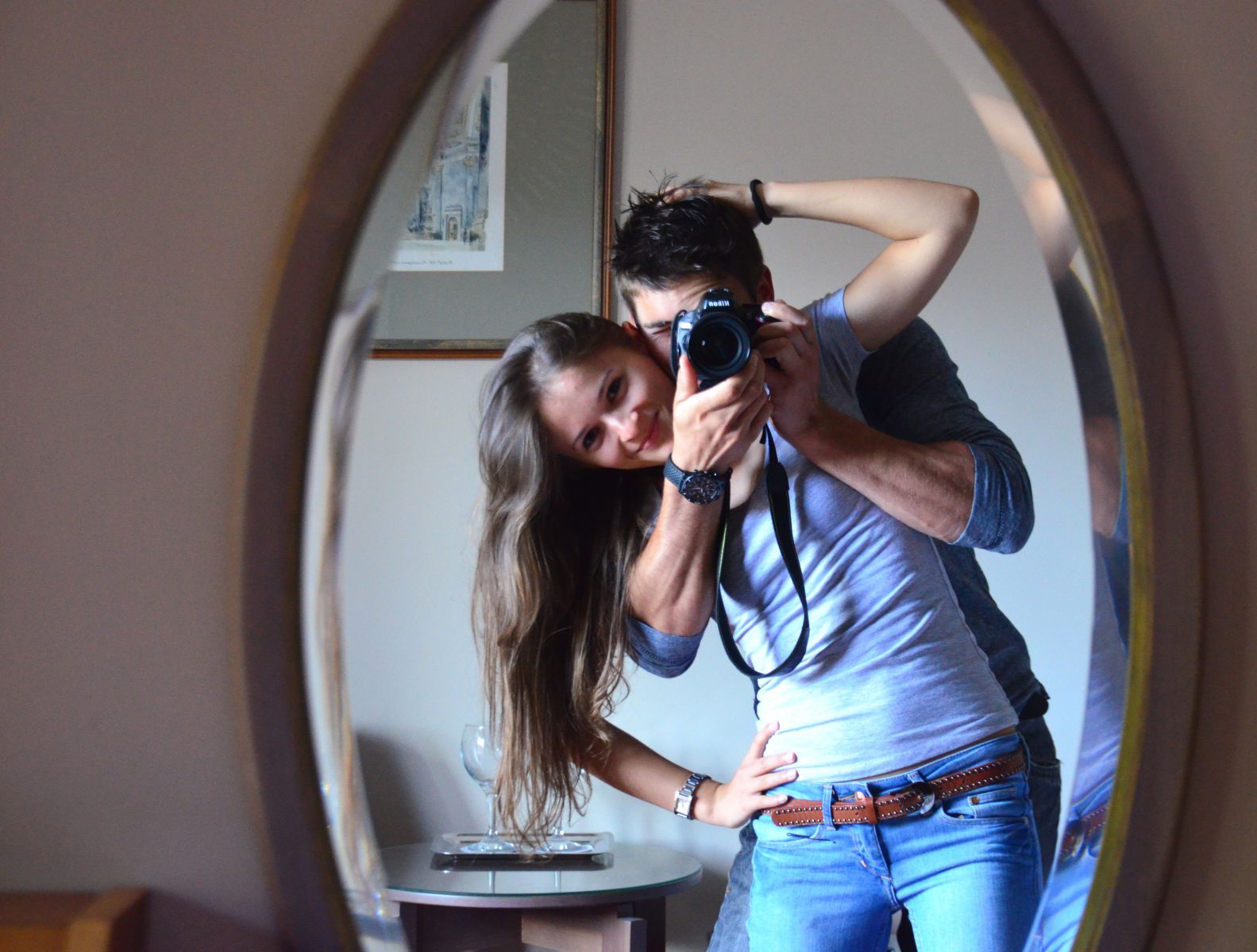 Homem e mulher tirando foto do reflexo do espelho
