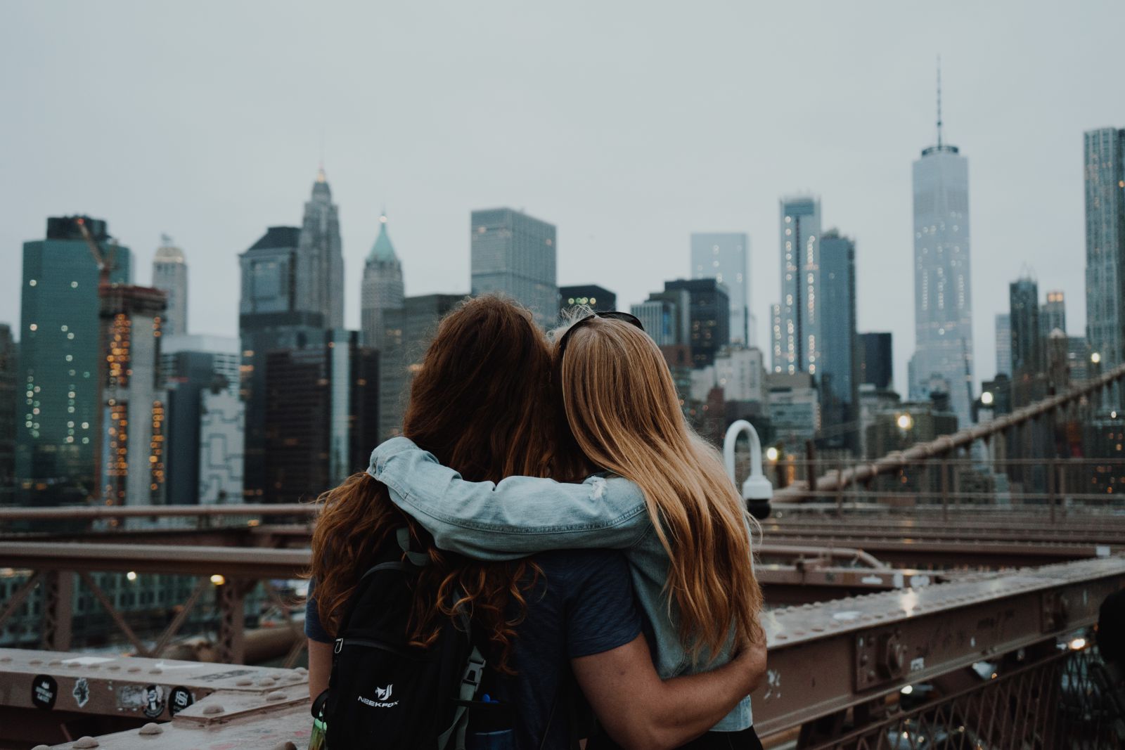Duas mulheres se abraçando olhando para a cidade