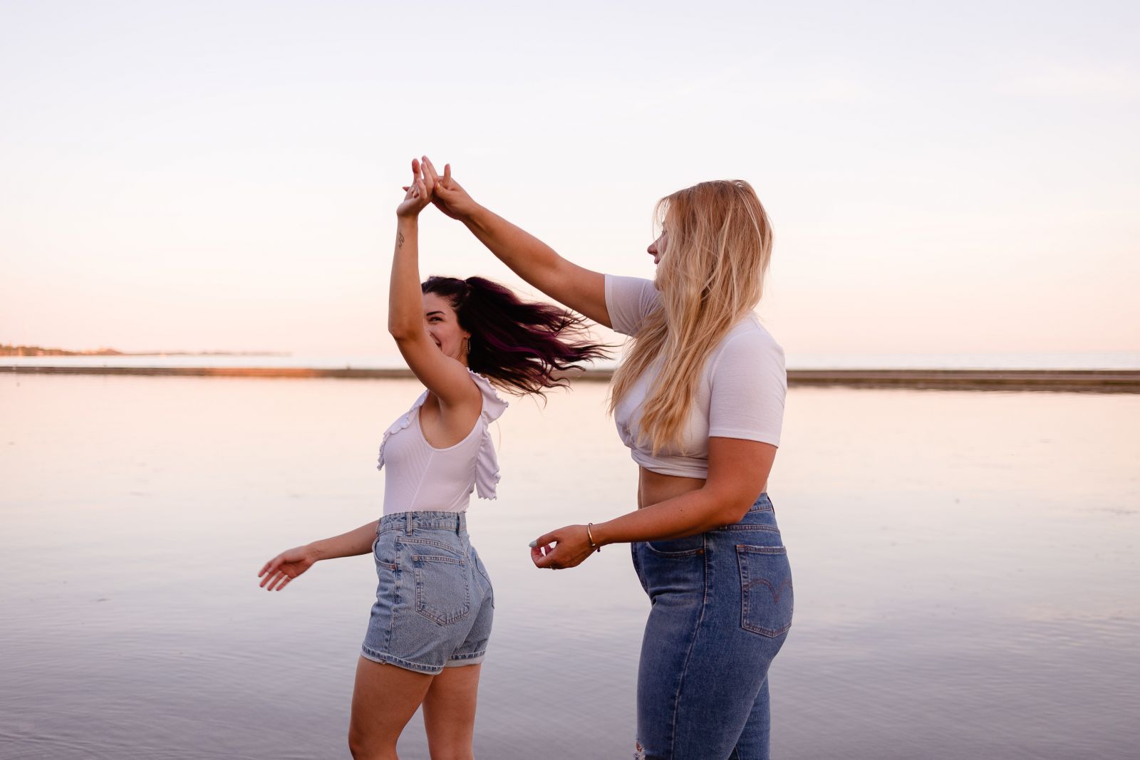 Duas mulheres dançando ao lado do mar