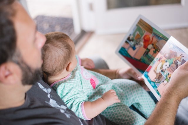 Pai lendo um livro infantil para seu filho bebê