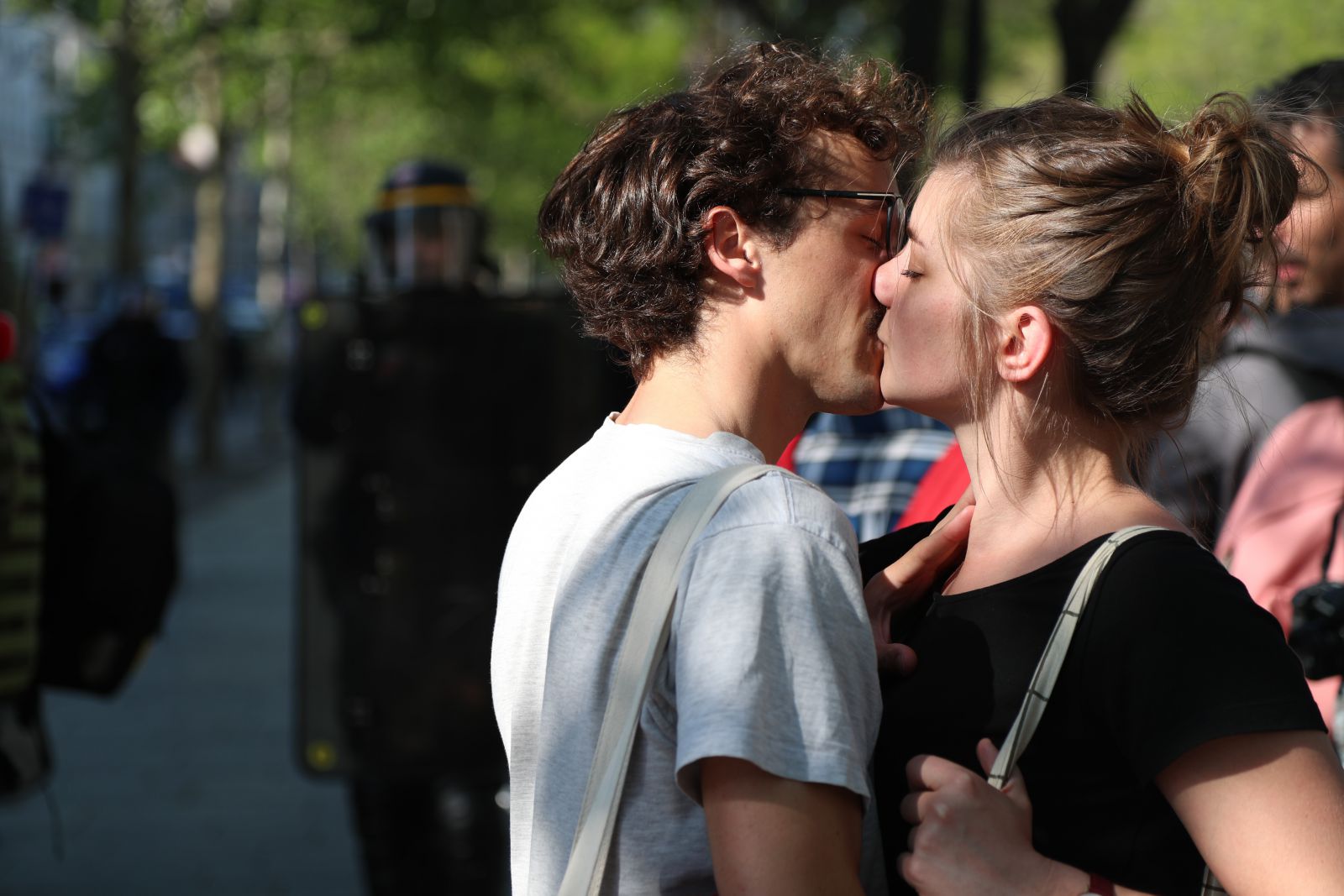 Homem e mulher se beijando ao lado de outras pessoas