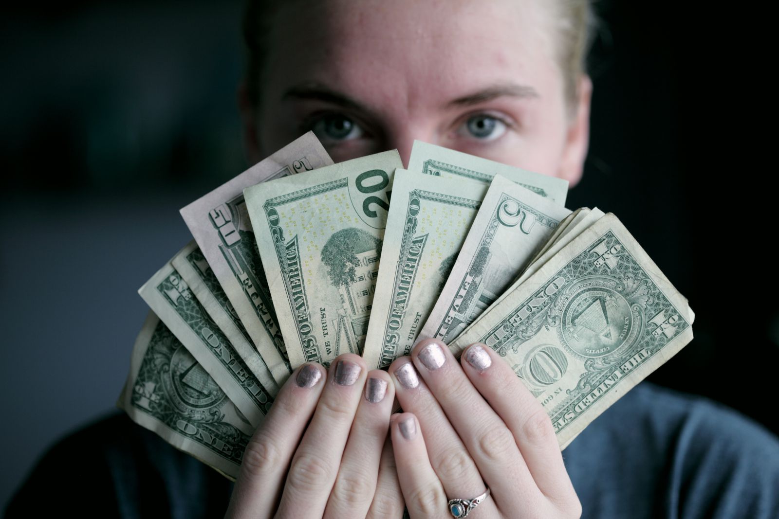 Pessoa segurando notas de dinheiro em frente ao seu rosto