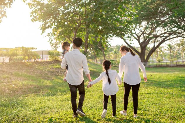 Família composta por dois adultos e duas crianças, três deles vestidos de branco.