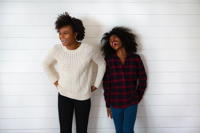 Mulheres negras lado a lado com expressões sorridentes.