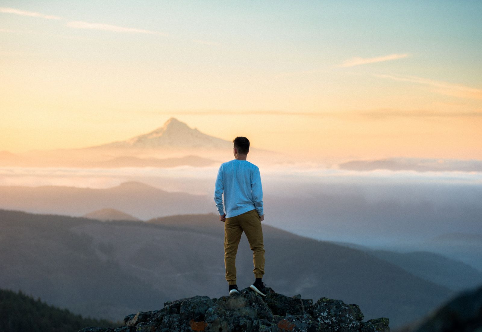 Homem em pé em uma montanha olhando para frente