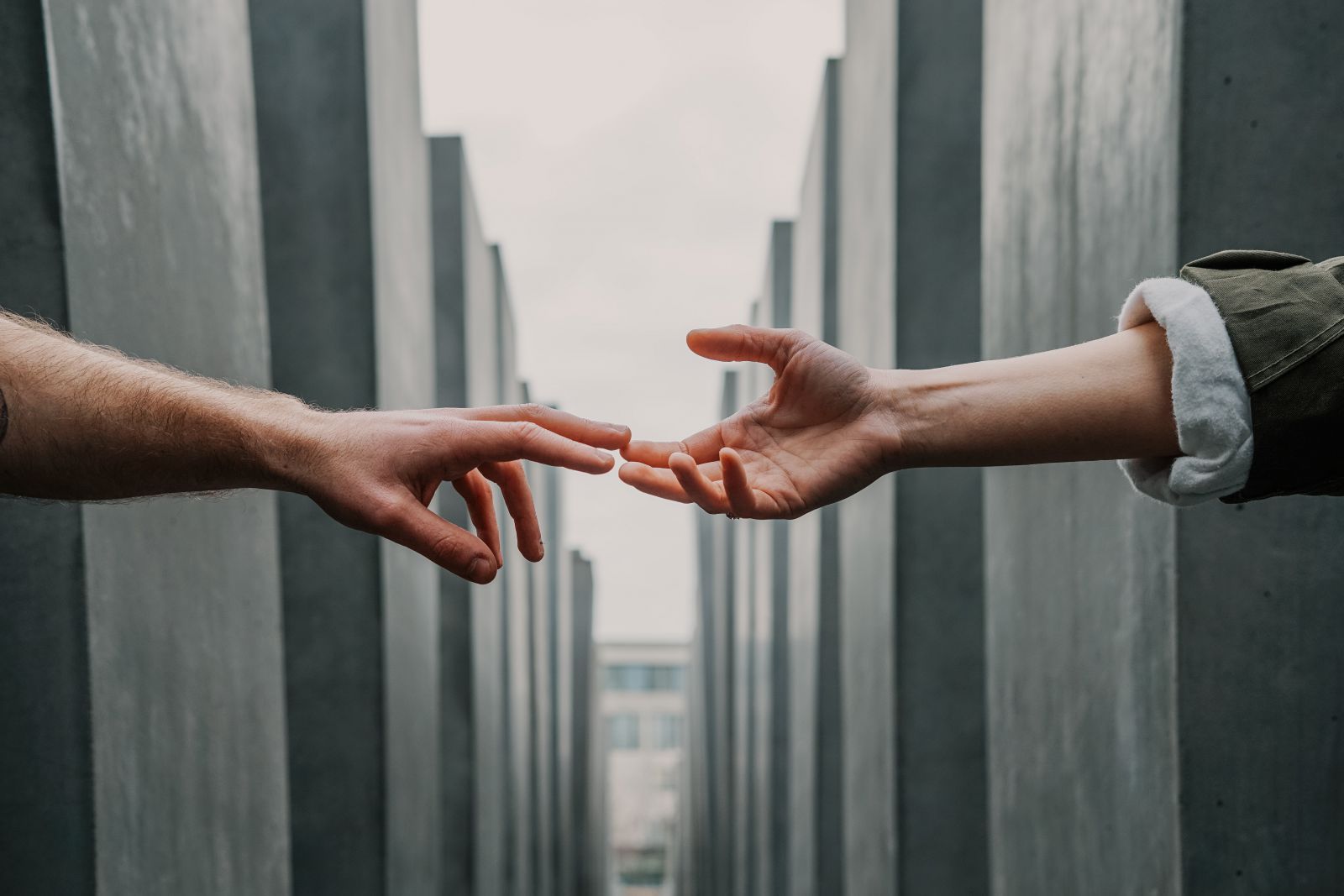 Duas mãos no centro em meio a colunas de concreto 