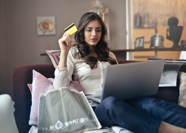 Mulher sentada em frente ao notebook fazendo compras online