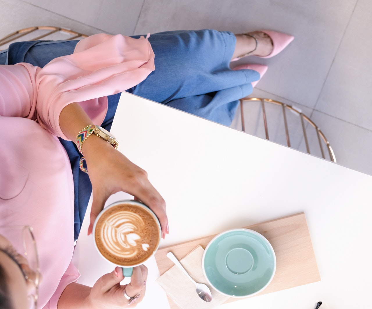 Mulher com roupas sociais tomando café.