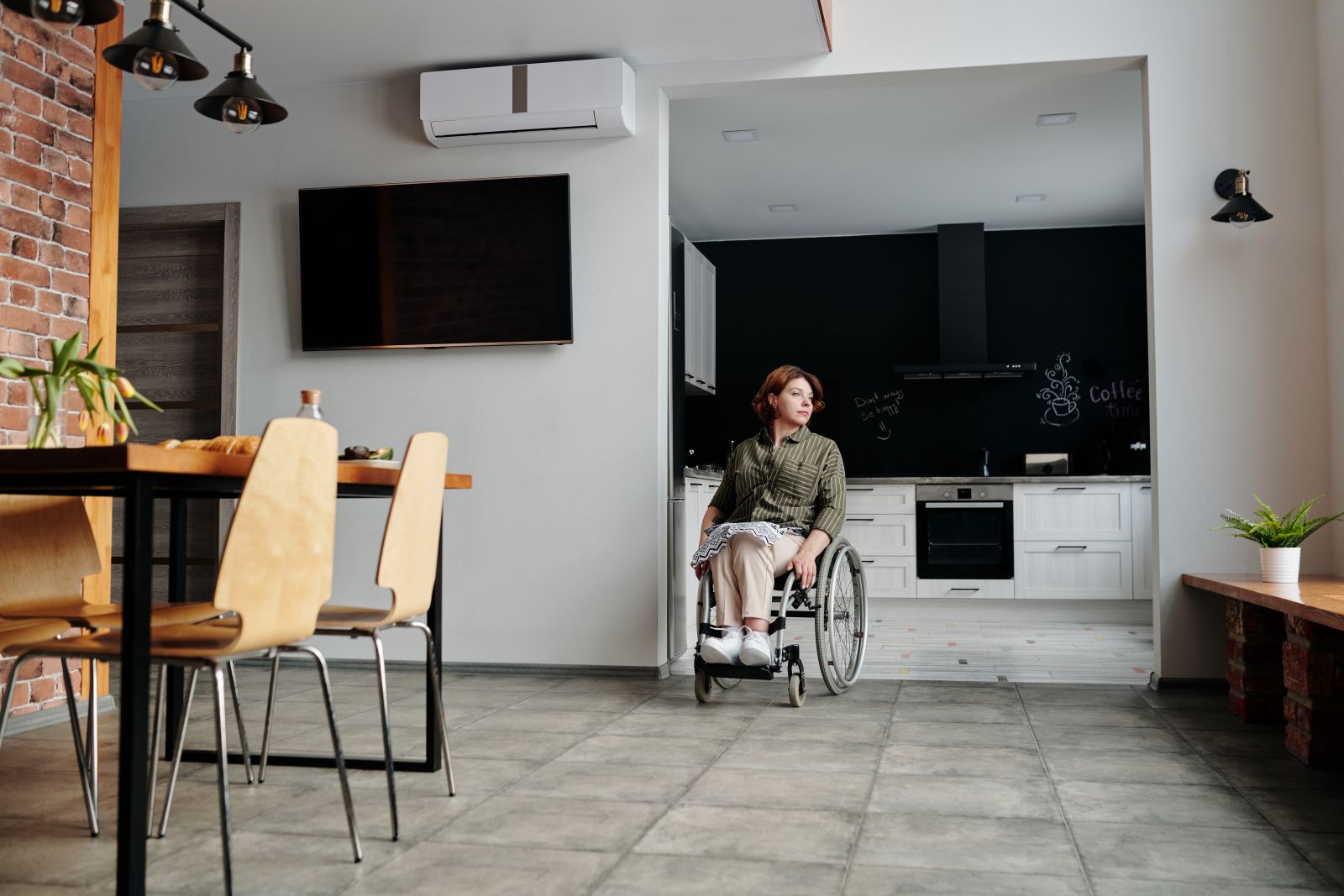 Mulher em cadeira de rodas sozinha em sua casa.